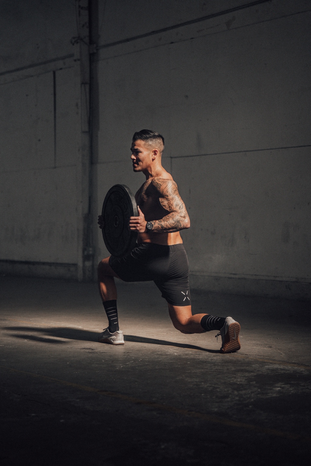 Athlete performing a loaded lunge in a studio
