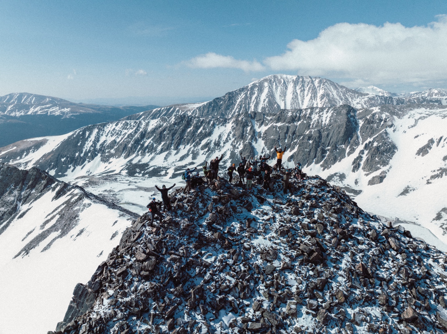 Group reaching a snowy mountain summit